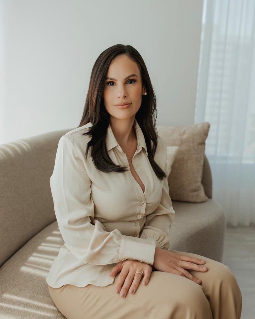 Mariana Muniz, nutricionista, sentada em um sofá claro